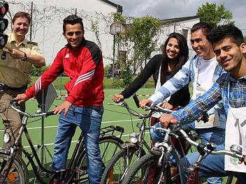 Verkehrserzieher Matthias Kleren (von links) erläutert den Flüchtlingen Shoaib Hamidi, Suzan Ahmad, Aman Mohammadi und Ahmad Schoaib Saqebi unter anderem das richtige Verhalten an einer Kreuzung mit Ampel.