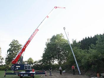 Der Kran hievt den Flutlichtmast, der über 340 Kilo wiegt, empor und stellt ihn ins Lot. Foto: Sonja Adam