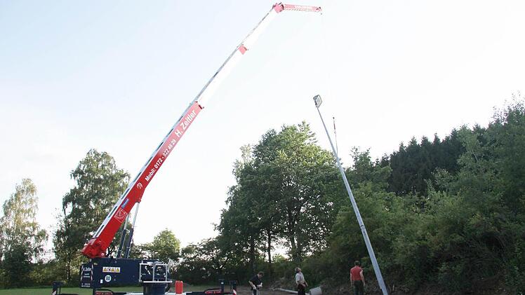 Der Kran hievt den Flutlichtmast, der über 340 Kilo wiegt, empor und stellt ihn ins Lot. Foto: Sonja Adam
