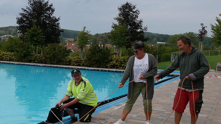 Wasserwart Alexander Mauer (von links),  Barbara Keller (Förderverein) und Hausmeister Steffen Haas ziehen im Maßbacher Freibad die Eispuffer fest. Für die Maßbacher war es eine sehr gute Saison.
