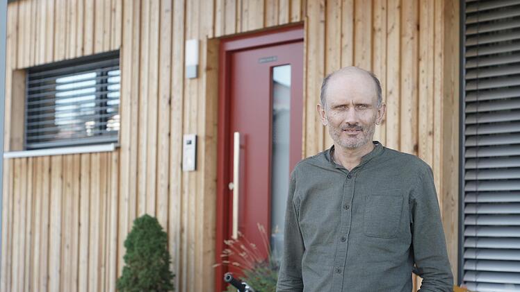 Michael Albert vor einem  holzvertäfelten sogenannten Tiny-Haus. Der Burkardrother Unternehmer möchte Fertighäuser so energieeffizient wie möglich anbieten.