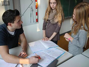 Johanna und Lara haben es sich bei den Matheaufgaben etwas zu einfach gemacht. Sascha Hammer erklärt, wie es richtig geht. Fotos: Julia Riegler