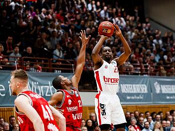 Der Würzburger Cameron Wells (links) kommt zu spät und kann den Distanzwurf von Jordan Crawford nicht mehr verhindern. Mit 23 Punkten, davon fünf Dreiern, war der Bamberger Neuzugang auch im zweiten Spiel der beste Werfer seines neuen Teams. Foto: Daniel Löb