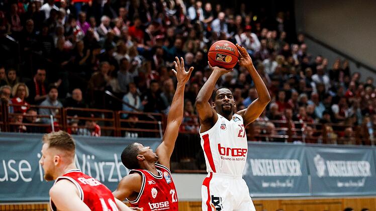 Der Würzburger Cameron Wells (links) kommt zu spät und kann den Distanzwurf von Jordan Crawford nicht mehr verhindern. Mit 23 Punkten, davon fünf Dreiern, war der Bamberger Neuzugang auch im zweiten Spiel der beste Werfer seines neuen Teams. Foto: Daniel Löb
