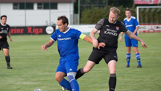 Unterrodachs Kapit&auml;n Lukas Hambach (blaues Trikot) erwartet beim TSV Tettau ein umk&auml;mpftes Spiel. In dieser Szene setzt er sich gegen Kevin Pfalz durch, der mit dem FC Hirschfeld den Tabellenf&uuml;hrer FC Wallenfels empf&auml;ngt.  Foto: Heinrich Wei&szlig;