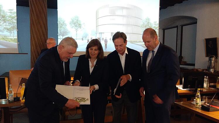 In Form von zwei gebundenen Büchern überreichten die Vertreter der Globe Coburg GmbH ihre Pläne an Oberbürgermeister Norbert Tessmer (links). Neben ihm Tina-Maria Vlantoussi-Kaeser, Michael Stoschek und Klaus-Jürgen Heitmann (von links). Foto: Simone Bastian