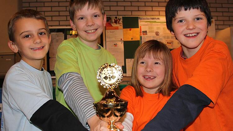 Strahlende Gesichter nach dem Hattrick: Tobias Kolb (Klasse 2b, von links), Daniel Wiemann (4a), Vanessa Wiemann (1a) und Nick Birkner (4a) holten den dritten oberfränkischen Meistertitel in Folge für die Grundschule am Markt/Seubelsdorf. Foto: Christa Burkhardt