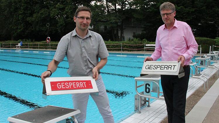 Das Coburger Freibad öffnet am Pfingstsamstag. Betriebsleiter Jörn Pakoßnick-Kirchner (links) und SÜC-Prokurist Joachim Gronau räumen schon einmal die Sperr-Schilder von den Startblöcken. Foto: Ulrike Nauer