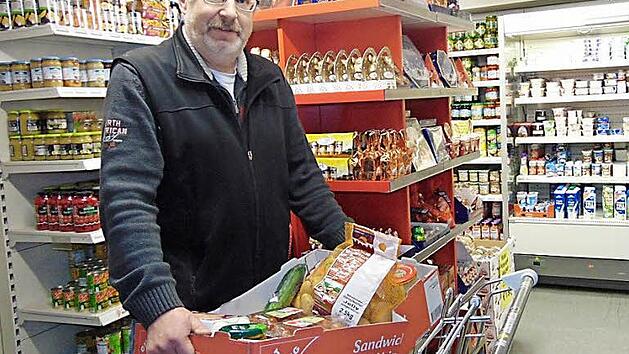 Armin W&ouml;lfel packt f&uuml;r seine Kunden eine Kiste mit Lebensmitteln.  Foto: Petra W&ouml;lfel