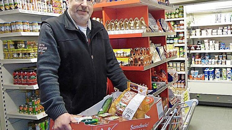Armin Wölfel packt für seine Kunden eine Kiste mit Lebensmitteln.  Foto: Petra Wölfel