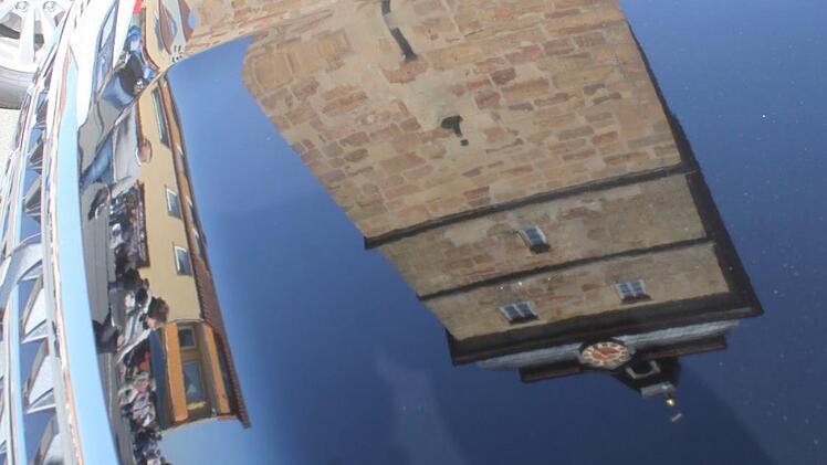 Das Stadtturm spiegelt sich im Lack eines ausgestellten Wagens. Foto: Matthias Einwag