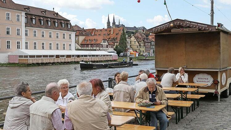 Alles ist bereit: Am Donnerstag startet die Sandkerwa 2013. Schon am Dienstag nutzten Touristen die am Kranen aufgebauten Tische und Bänke für eine kurze Verschnaufpause. Im Hintergrund das Festzelt am Leinritt.  Fotos: RiegerPress
