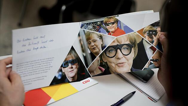 Blick in eine CDU-Brosch&uuml;re mit Portr&auml;ts von Bundeskanzlerin Angela Merkel Foto: Kay Nietfeld, dpa