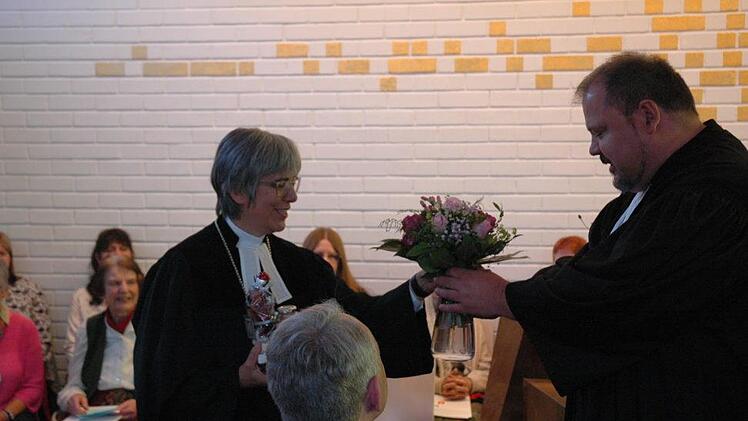 Pfarrer Detlev Juranek überreicht  Regionalbischöfin Dorothea Greiner Tartufos und Blumen als kleines Dankeschön. Foto: Edwin Meißinger
