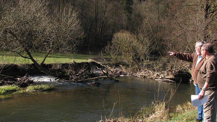 Die Vorsitzenden Armin Sauermann (links) und Erwin Trapp begutachten eine der Verklausungen an der Sinn. Hier hat sich aus Tot- und Treibholz eine Barriere gebildet. Die Folge: Das Wasser staut sich, der gegenüberliegende Uferbereich erodiert immer mehr. Es kommt zu massivem Uferabtrag und zur Verschlammung von Kiesbänken. Foto: Karlheinz Franz