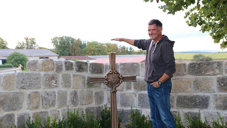 Peter Memmel zeigt an, wie hoch die Naturscheinmauer am Kreuz noch werden soll.Heike Beudert