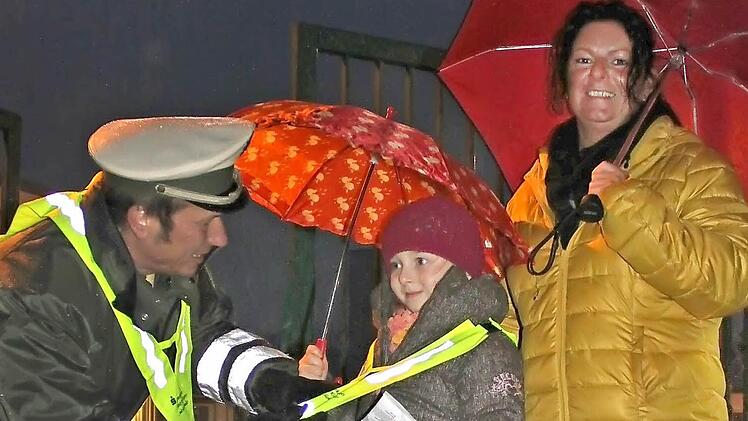 Die sechsjährige Zoe trägt stolz ihr Sicherheitsdreieck. Ihre Mutter Petra Tüchert (rechts) lässt sie nicht ohne aus dem Haus. Von Polizist Dietmar Dömling gab es dafür zur Belohnung Gummibärchen.  Foto: Sabine Herteux