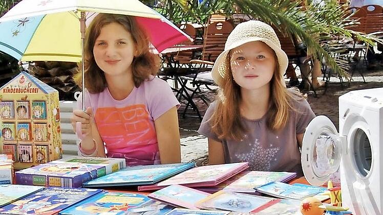Hannah (11, links) und ihre Schwester Mila (8) warten auf interessierte Kunden. Die kommen dann auch schon. Foto: Sigismund von Dobschütz