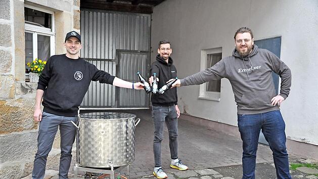 Die Bierrebellen von Ermershausen (von links) Patrick Rädlein, Patrick Hörner und Andreas Engmann mit ihrem Braukessel. Mit dem selbstgebrauten „Rebell Hell" stößt das Trio auf weitere Brauerfolge an.