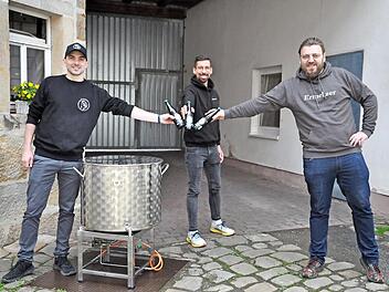 Die Bierrebellen von Ermershausen (von links) Patrick Rädlein, Patrick Hörner und Andreas Engmann mit ihrem Braukessel. Mit dem selbstgebrauten „Rebell Hell" stößt das Trio auf weitere Brauerfolge an.