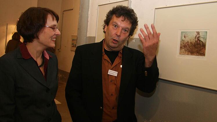 Stephan Klenner-Otto erklärt Astrid Fick und zahlreichen anderen Ausstellungsbesuchern seine Arbeiten.