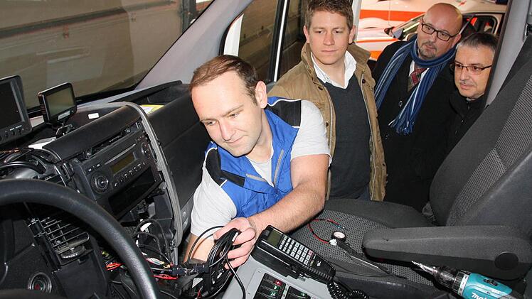 Techniker Frank Juhl baut in dieser Woche die neuen GPS-Geräte in sämtliche Rettungsdienst-Fahrzeuge im Landkreis Bad Kissingen ein. Dabei schauten ihm gestern (von rechts) Leitstellen-Leiter Thomas Schlereth, der Leiter Einsatzdienste Rudolf Baier und Michael Schmidmeier von GHT über die Schulter. Fotos: Ralf Ruppert