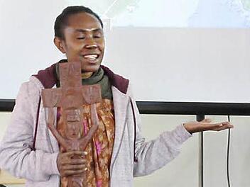 In einer Hand das Kreuz, in der anderen Hand die Geste des verbindenden christlichen Glaubens: Lehrerin Naomi Binora berichtete von ihrer Arbeit in der Frauenschule Gatop in Papua-Neuguinea.  Foto: Manfred Wagner