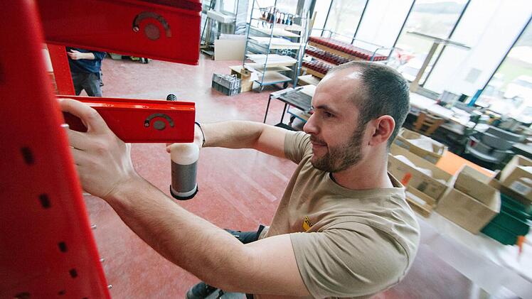 Ein ruhiges Händchen: Der Konstruktionsmechaniker Fitim Aliu (25) justiert mit einem Hammer Schließfach-Türen. Foto: Marian Hamacher