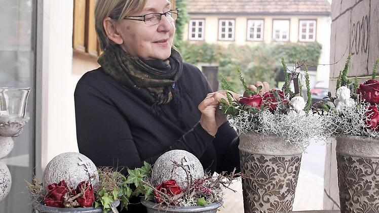 Angelika Nußbaum hat für Allerheiligen schon ein paar Gestecke vorbereitet. Besonders gerne nimmt sie dafür rote Wachsrosen.
