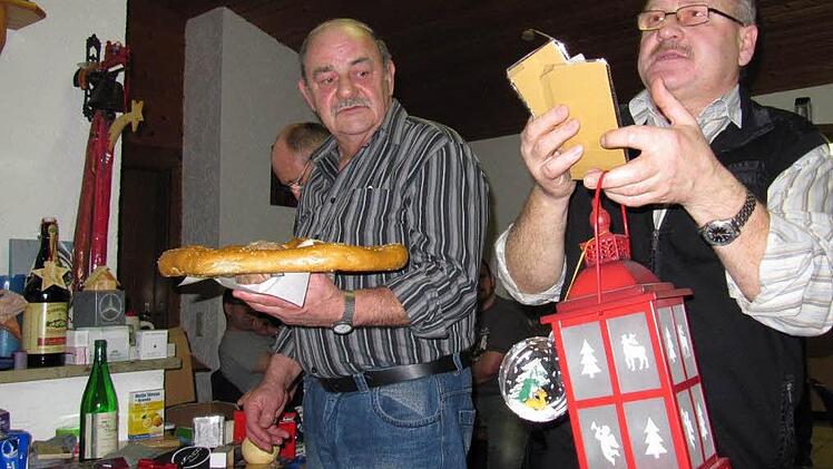 Das geht ja ruckzuck: Siegfried Unrein (links) hält schon die nächsten Posten in der Hand - derweil preist Bernhard Wagner noch eine "Nachtwächterlaterne" nebst Christbaum-Dekoration an. Foto: Monika Schütz