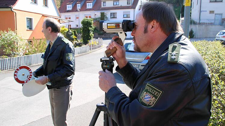 Polizist Werner Rottmann (rechts) misst mit der Laserpistole die Geschwindigkeit. Sein Kollege Dietmar Vogel winkt die Fahrer her.