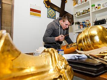 Lukas Nagel beim "Anschießen". Der Azubi vergoldet hier den Unterbau eines Kreuzes vom Querhaus der Kirche St. Michael in Bamberg.  Foto: Matthias Hoch