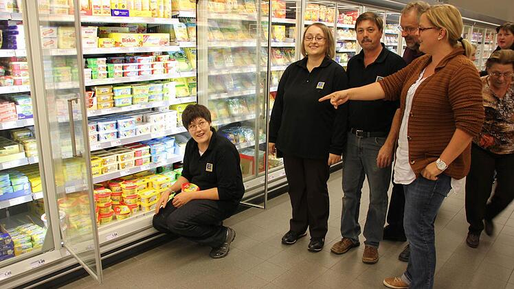 Christina beim Einräumen mit  Marktleiter Klaus Rother,  Ausbilderin Silke König, Peter Pratsch  (mit Bart) und Isabell Kuhn.