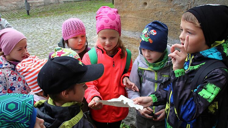 Eine Geocaching-Tour auf Martin Luthers Spuren bietet jetzt die Initiative Rodachtal in Heldburg an. Am Donnerstag konnten Schüler der Grundschule Hellingen sie erstmals testen. Nick (rechts) hat den ersten Cache gefunden und den Text vorgelesen. Jetzt hat er eine Idee, wie die Antwort auf die gestellte Frage lautet. Foto: Bettina Knauth