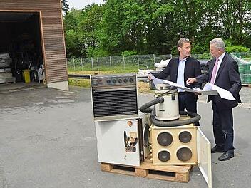 Landrat Oswald Marr (rechts) und Thomas Mattes erörtern den Bauplan im Wertstoffhof Birkach. Einige Meter rechts neben der Holzhalle im Hintergrund wird eine weitere Halle zur Lagerung von Elektrogeräten entstehen. Foto: K.- H. Hofmann