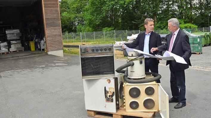 Landrat Oswald Marr (rechts) und Thomas Mattes erörtern den Bauplan im Wertstoffhof Birkach. Einige Meter rechts neben der Holzhalle im Hintergrund wird eine weitere Halle zur Lagerung von Elektrogeräten entstehen. Foto: K.- H. Hofmann