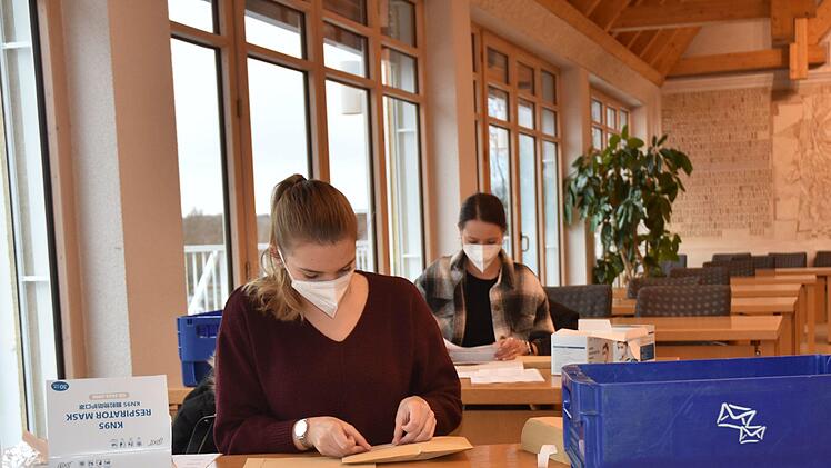 Mitarbeiterinnen des Landratsamtes und des Jobcenters in Haßfurt halfen im großen Sitzungssaal beim Verpacken der Masken.LRA