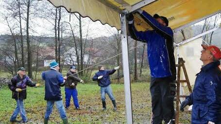Wer gemeinsam feiern will, muss auch gemeinsam anpacken: Kirmesherren  und -damen bauen das Festzelt auf und posieren am Querchstuhl, der dem Kirmesredner am Sonntag als Bühne dient.
