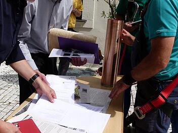 Dekan Hans-Martin Lechner, Pfarrer Walter Neunhoeffer und Handwerker fügten Dokumente aus dem Jahr 2019 in die neue Zeitkapsel ein. Foto: Marion Kürger-Hundrup