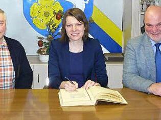 MdB Emmi Zeulner trug sich bei ihrem Gemeindebesuch in Rugendorf auch ins Goldene Buch ein. Mit im Bild Bürgermeister Ralf Holzmann (rechts) und sein Stellvertreter Fritz Rösch.  Foto: Klaus-Peter Wulf