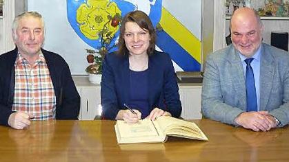 MdB Emmi Zeulner trug sich bei ihrem Gemeindebesuch in Rugendorf auch ins Goldene Buch ein. Mit im Bild Bürgermeister Ralf Holzmann (rechts) und sein Stellvertreter Fritz Rösch.  Foto: Klaus-Peter Wulf