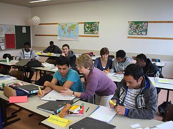 Klassenlehrerin Anja Steiner-Sieber (hinten Mitte) wird in ihrer Flüchtlingsklasse unterstützt von Karin Bigdeli (vorne Mitte), die von der VHS kommt.  Fotos: Andreas Dorsch