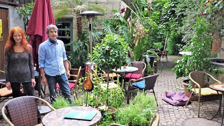 Üppiges Grün, mächtige Kirschbäume und plätscherndes Wasser verbreiten im Garten Café Karibik Urlaubsstimmung. Mit im Bild: Ulrike Bernardt und Martin Ludwig Fotos: Gerd Fleischmann