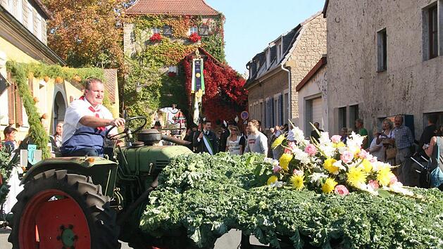 Mit viel Blumen und Gemüse schmückt die Burschenschaft die Festwagen, wie hier der von Georg Günther gesteuerten Bulldog.   Foto: Hartmut Heß