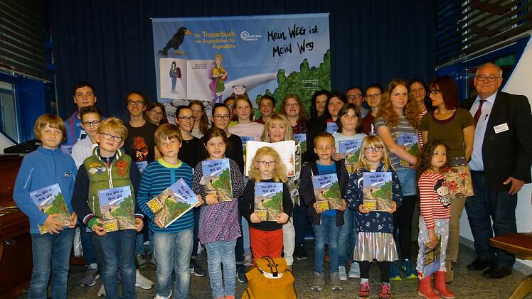 Die Kinder und Jugendlichen der Trauergruppe sowie Ehrengäste nahmen das druckfrische Buch entgegen. Foto: Marion-Krüger-Hundrup