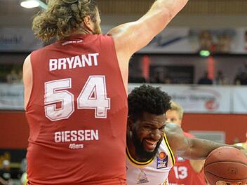 Hassan Martin prallt an der Gießener Wand in Gestalt von Center-Koloss John Bryant ab. Foto: Peter Mularczyk