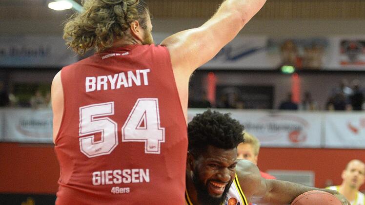 Hassan Martin prallt an der Gießener Wand in Gestalt von Center-Koloss John Bryant ab. Foto: Peter Mularczyk