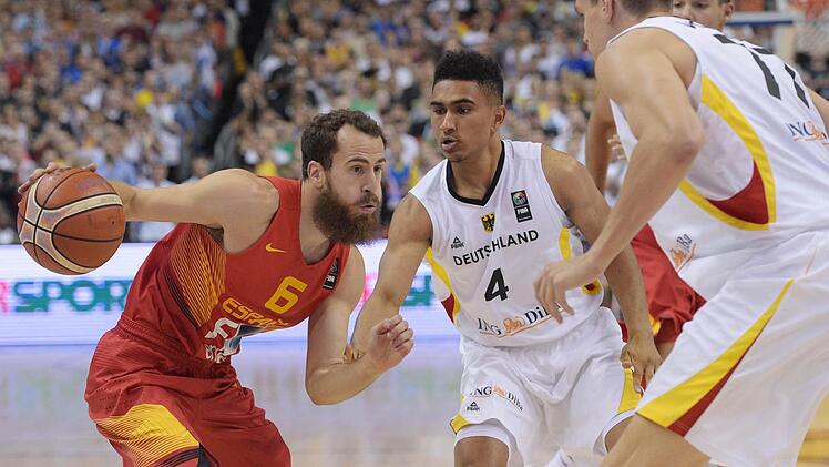 Spaniens Sergio Rodriguez bereitet einen Angriff vor. Deutschlands Deutschlands Maodo Lo (M) und Teamkollege Johannes Voigtmann wollen das verhindern. Foto: Rainer Jensen/dpa