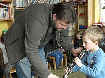 Der Musikpädagoge und Dirigent des Musikvereins Weißenbrunn, Marco Plitzner, erweckte die Neugier der Kleinen im Kindergarten Fridolin für Blasinstrumente. Benedikt darf auf einer Klarinette üben. Foto: K.-H. Hofmann