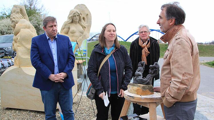 Manfred Reinhart (rechts) erklärt die Symbolik seiner Sandsteinskulptur. Unter den Zuhörern sind MdB Andreas Schwarz (links) und Anne Schmitt vom Flussparadies Franken.